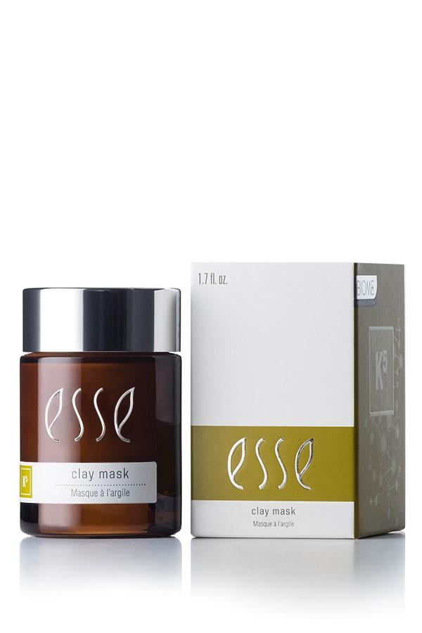 An image displaying the Esse Clay Mask shows a brown jar with a black lid and a white label featuring the brand name "Esse" and the text "clay mask Masque à l’argile." Accompanying it is a white box with matching branding and a green accent on the front.